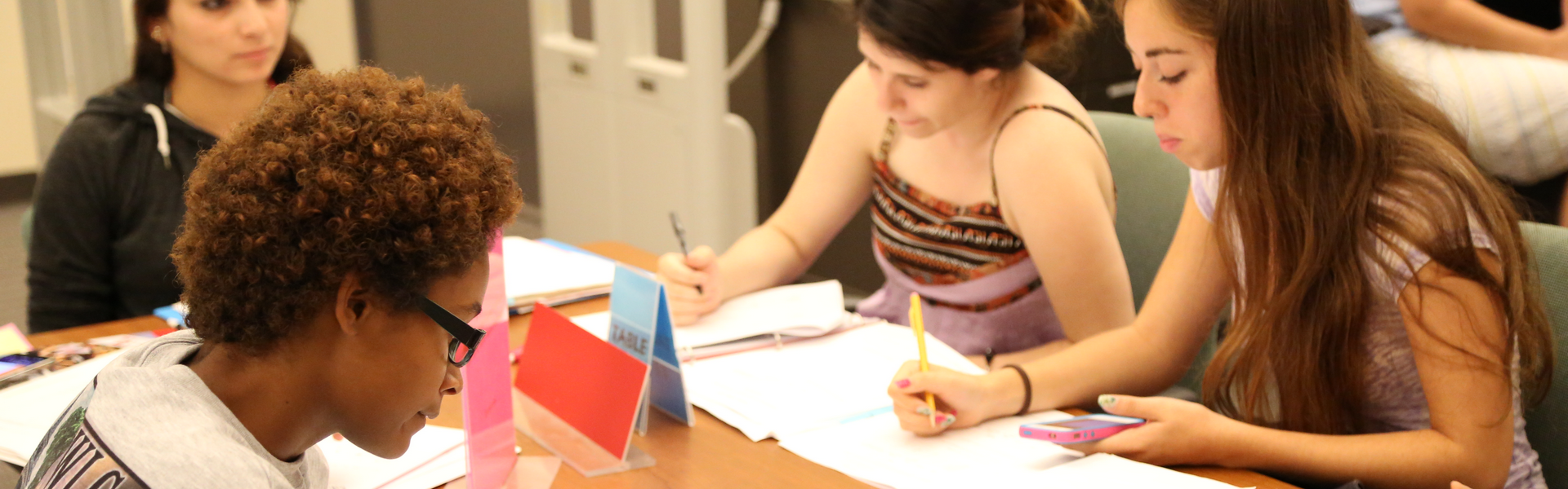 A group of students studying at a large table.