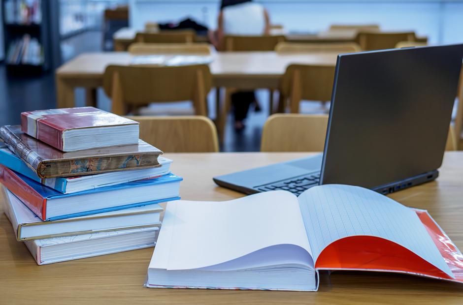 Stack of books on table top in the library / Education & Back to school concept 