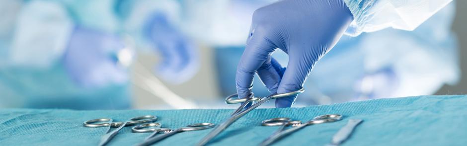 Close-up of scrub nurse taking medical instruments