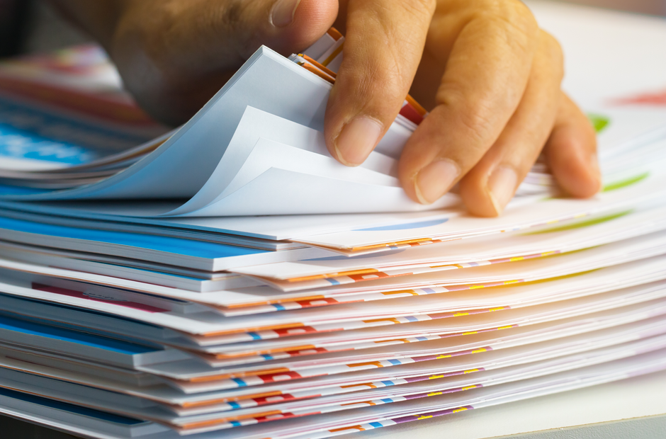 A person flipping through paper forms.