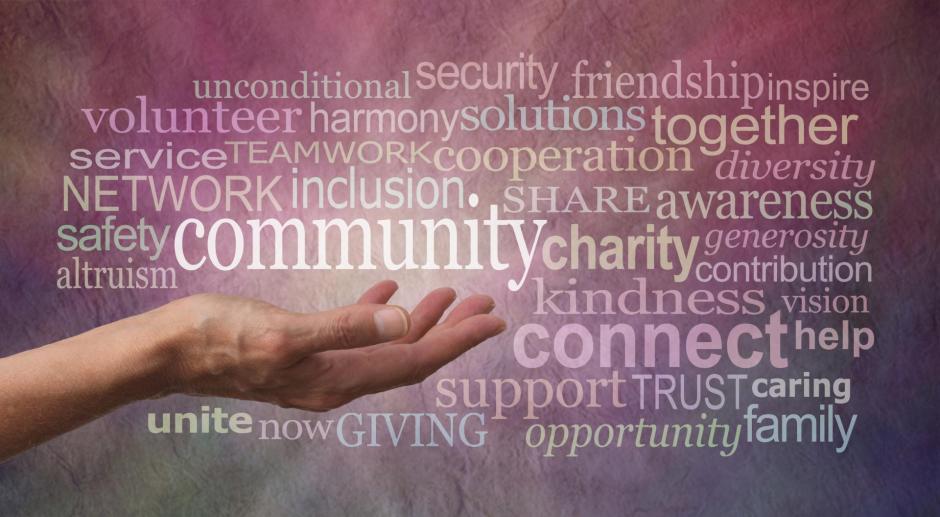 Female open hand against a rustic stone effect pink purple banner background with the word COMMUNITY above surrounded by a word tag cloud