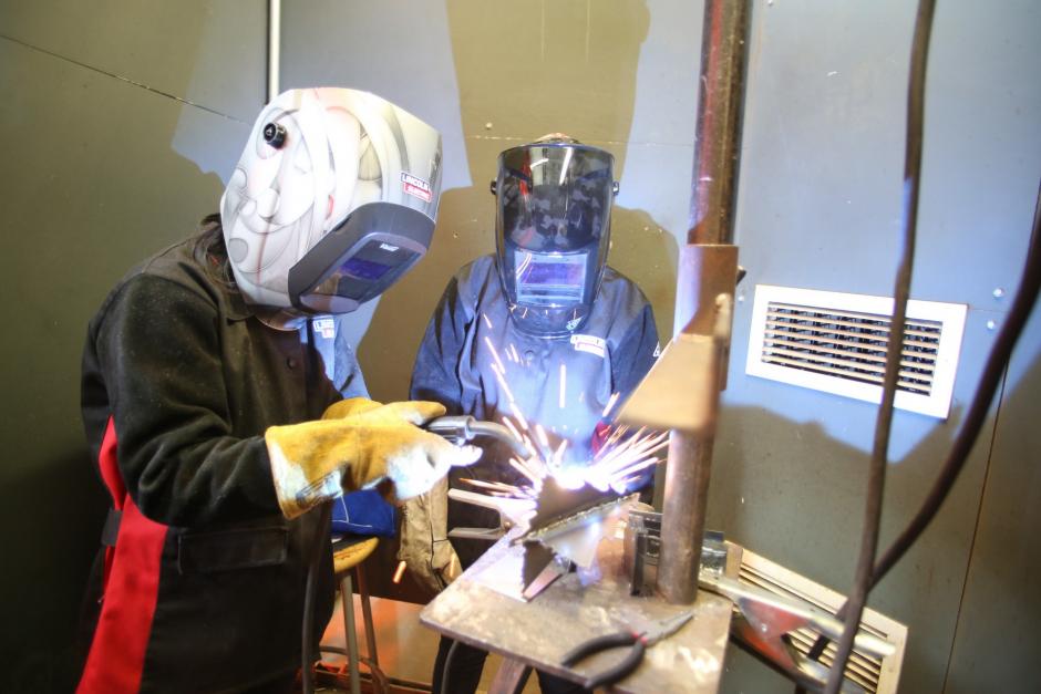 High school students spot-welding Christmas ornaments.