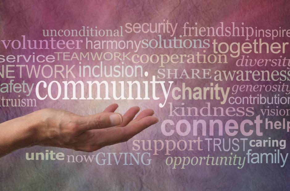 Female open hand against a rustic stone effect pink purple banner background with the word COMMUNITY above surrounded by a word tag cloud