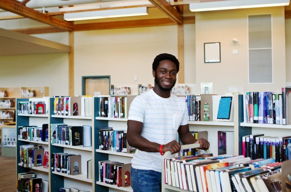 A librarian pushing a cart of books.