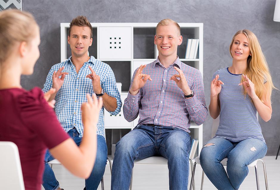 Group of young people learning a sign language