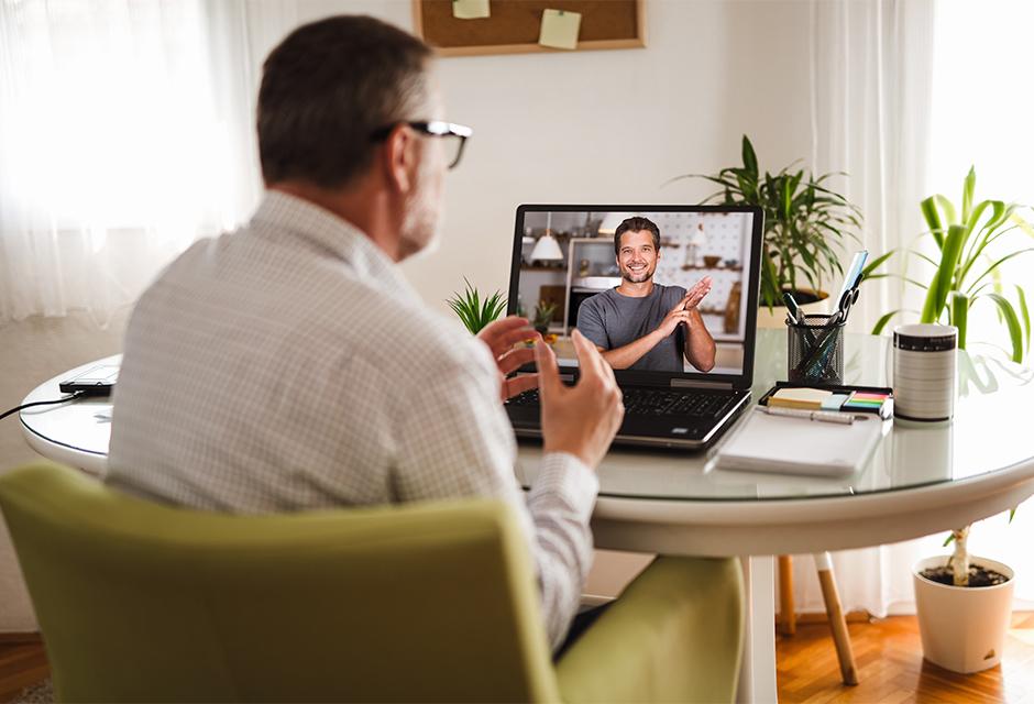 Deaf man talking using sign language on the laptop at home.