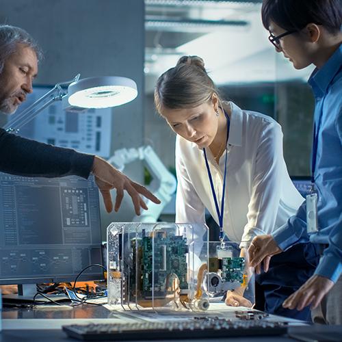 Team of Scientists Choose Between Printed Circuit Board to Work With. In The Background Technologically Advanced Scientific Research Center